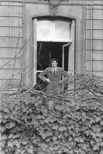 Foto vintage de Anthony Perkins em pé na janela.